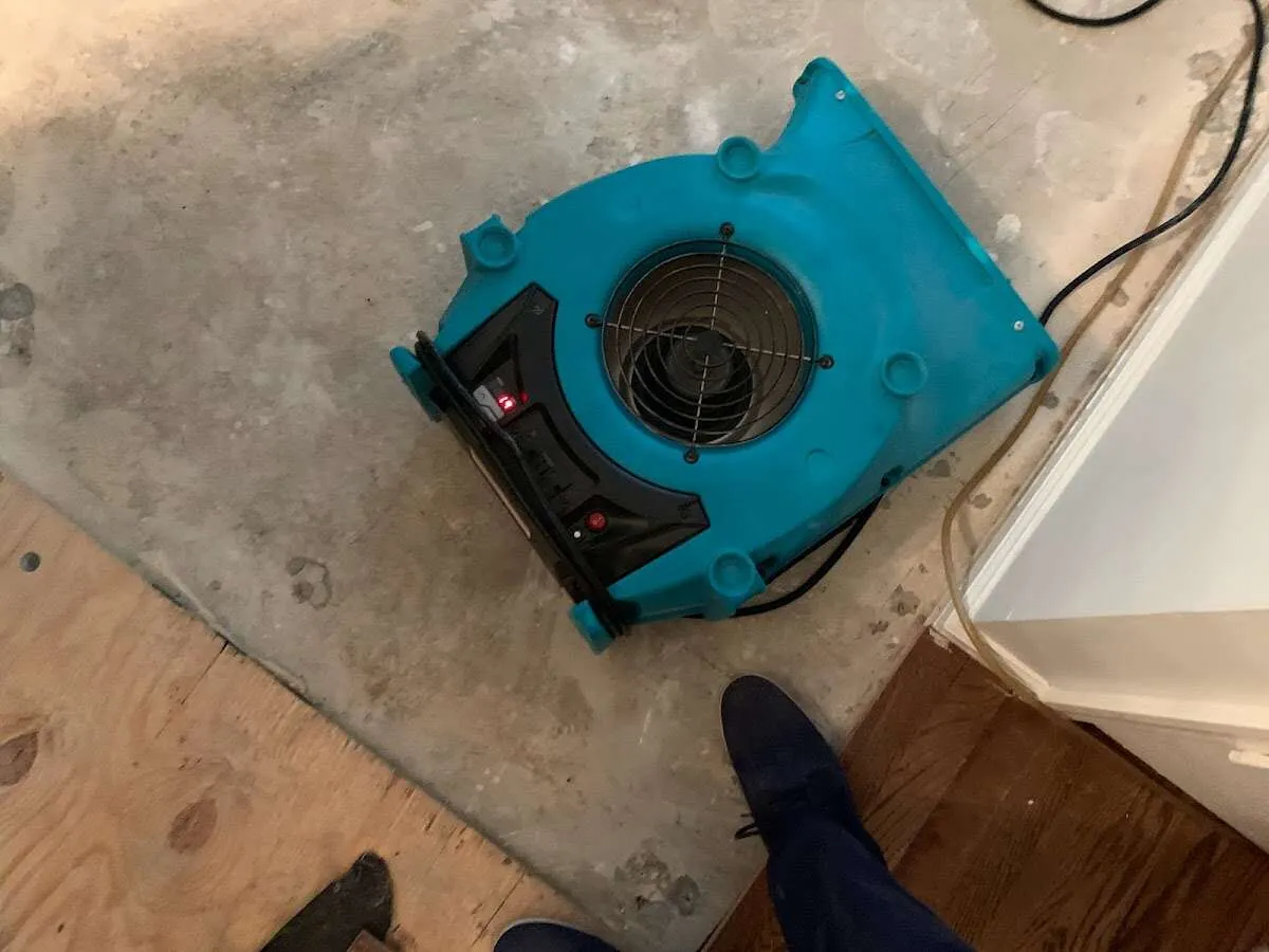 Air mover drying subfloor during Leak Detection & Repair in Benton